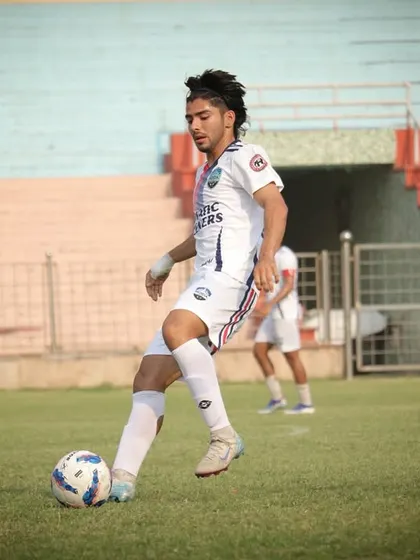 A senior player in action, controlling the ball with precision during our first match.
