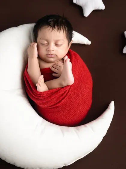 I love you to the moon and back. This classic pose with the baby nestled on a crescent moon pillow is always a favorite among parents.