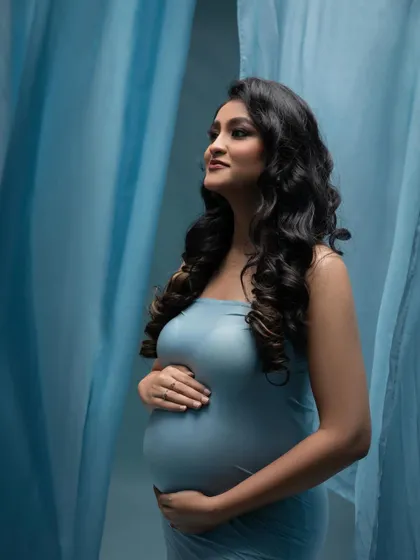 Looking towards the future. This profile shot in the blue gown captures a sense of hope and anticipation, with the soft fabric creating a beautiful frame.