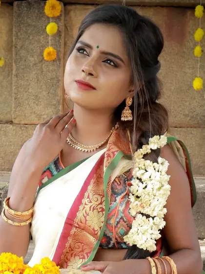 Lost in the festive moment. This image captures the grace of the traditional Onam look, with soft makeup that enhances her natural features beautifully.