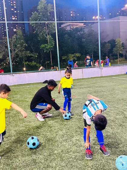 A coach helps a young player with his ball control. We provide one-on-one attention to ensure every child is learning correctly.