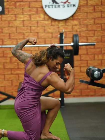 When you understand the game, you don't panic. A powerful kneeling pose at Peter's Gym, showcasing my back and bicep definition. Confidence comes from preparation.