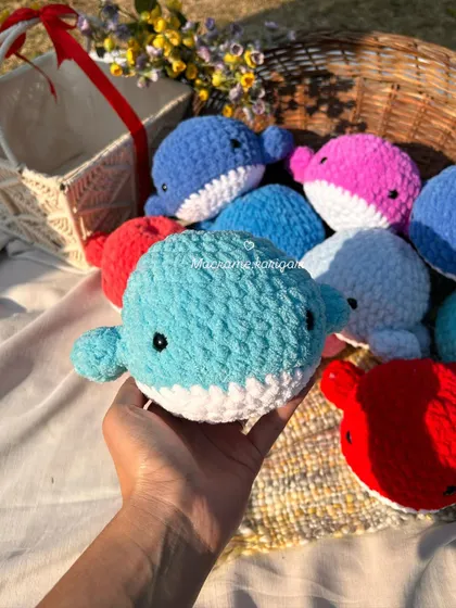 A close-up of a light blue crochet whale. You can see the soft texture of the yarn and the simple, sweet embroidered eyes that make our toys safe for all ages.