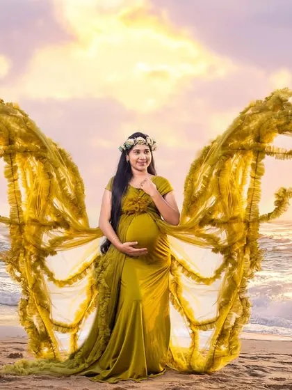 A creative edit adds golden butterfly wings to this beach portrait, elevating a beautiful photo into a piece of fantasy art.
