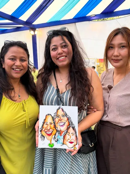 A group of friends enjoying their time at a mela and getting a fun group caricature to remember the day.
