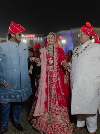 A candid moment from Bhavika's wedding day. Her classic red lehenga is paired with a fresh and glowing makeup look, making her look absolutely beautiful as she walks with her family.
