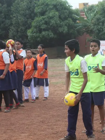 Students line up for a game, holding balls and wearing bibs. Organized activities on special days help strengthen the bond between the children and our programs.