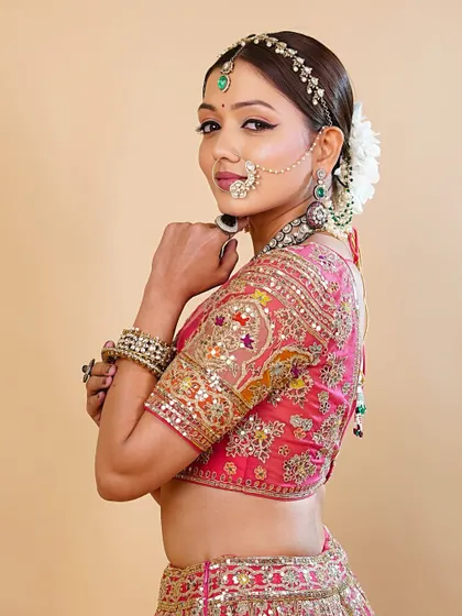 This side portrait shows how the makeup and hair come together to create a clean, regal silhouette, perfectly complementing the vibrant bridal lehenga.