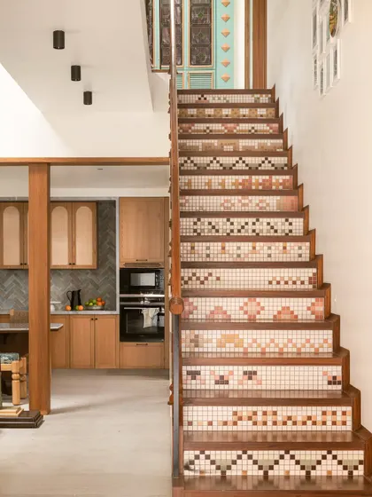 The staircase in our Kolam Pop home is a rhythmic dance of geometry and material. Each solid wooden tread is complemented by a riser in mosaic tiles with abstracted Kolam patterns.