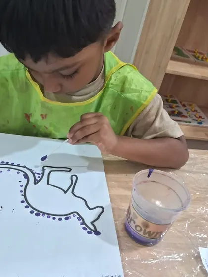 We explore art from around the world, like this Aboriginal dot painting activity. Using a cotton swab, this child carefully makes purple dots along the outline of a kangaroo.