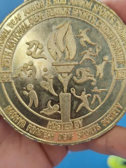 A duplicate image of the gold medal, celebrating the victory at the National Deaf Sports Championship.