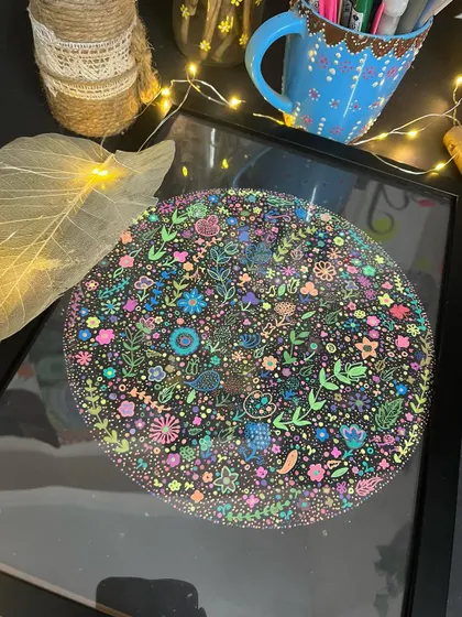 A framed floral doodle artwork, lit up with fairy lights.