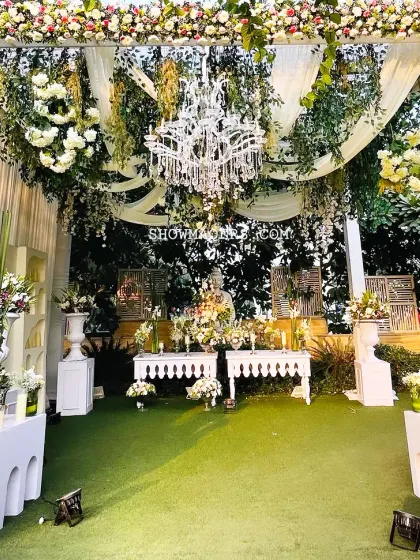 The main decor setup for the ivory themed wedding, featuring a grand chandelier and abundant white florals, creating a luxurious and serene ambiance.