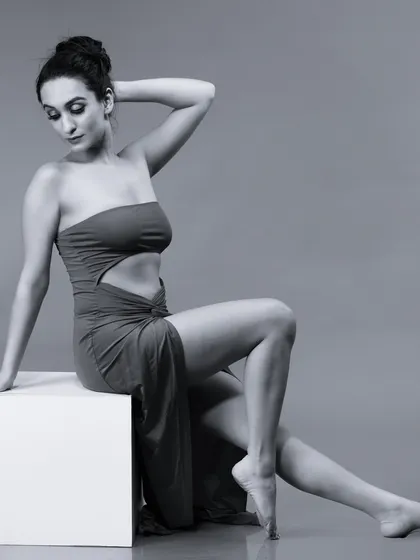 A graceful black and white pose, with the model's hand behind her head.