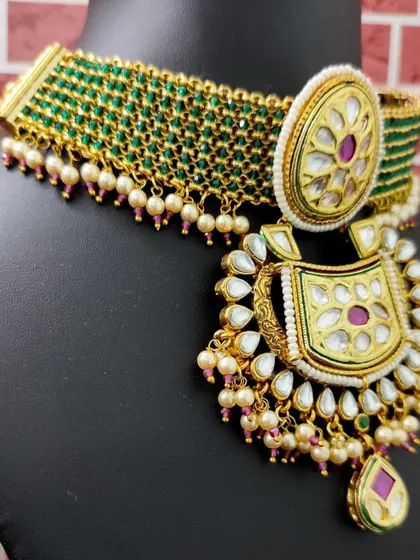 A beautiful green beaded choker with a large kundan pendant. This rental piece is perfect for adding a pop of color to your mehendi or sangeet outfit.