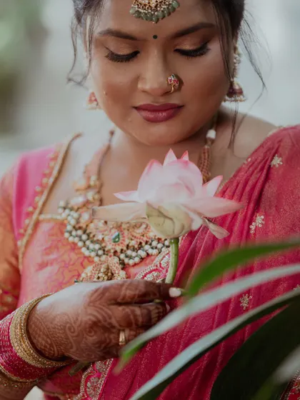 A portrait of a bride holding a lotus flower, symbolizing her grace and the beauty of new beginnings.