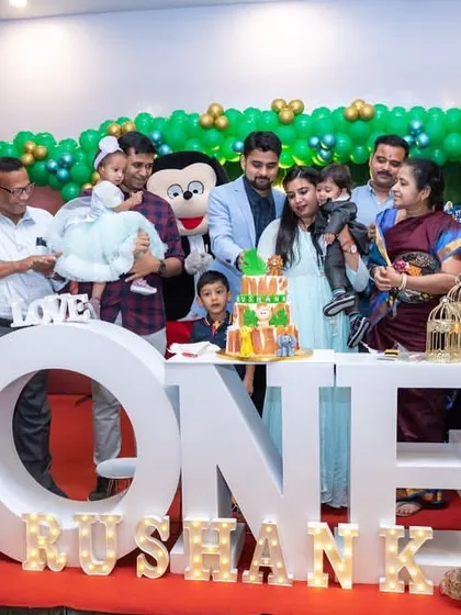 A large family group photo celebrating a first birthday with a jungle theme. We are experienced in organizing and capturing great shots of bigger family gatherings.