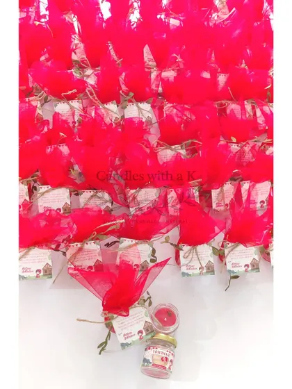 A 'Red Riding Hood' themed first birthday return gift. The crimson red candle with an Apple Cinnamon scent and matching red net wrap perfectly captures the essence of the classic fairytale.