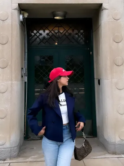 Posing in front of a historic building, my casual jacket and red cap add a pop of color.