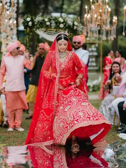 A stunning shot of the bride's entry, walking down a mirrored aisle that reflects the sky and decor, creating a magical and grand effect.