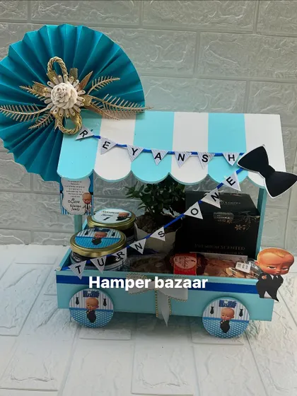 A Boss Baby themed cart hamper for Reyansh's first birthday, complete with a personalized name banner.