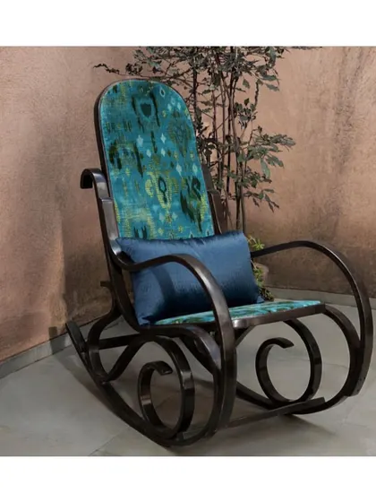 'Kadife Ikat' velvet fabric in rich hues of green adds a touch of regal comfort to this rocking chair. It's a perfect example of how a luxurious fabric can elevate a traditional piece of furniture.