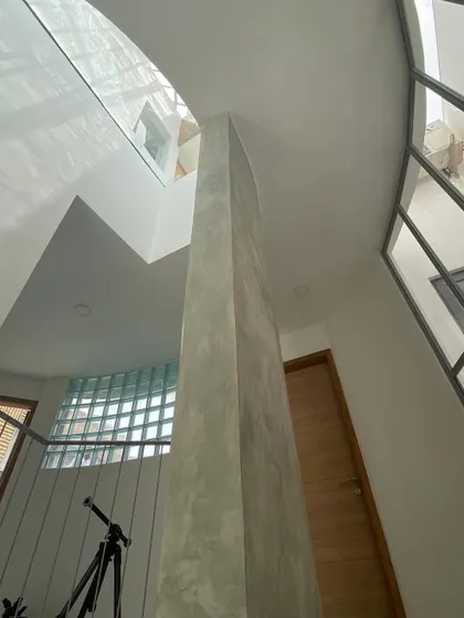 This view shows how the skylight and a concrete column work together to define the space and channel light through the home's core.
