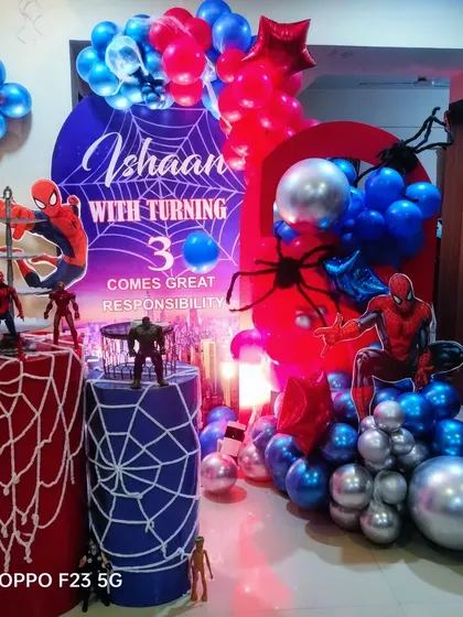 Your friendly neighborhood Spider-Man swung by for Ishaan's 3rd birthday. This dynamic setup includes spiderweb-covered pedestals, character figures, and a red and blue balloon arrangement for an action-packed party.
