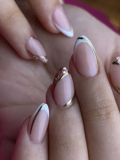 A modern and elegant take on the French manicure, featuring clean white and gold lines over a natural pink base. This versatile design is perfect for any special event where sophistication is key.