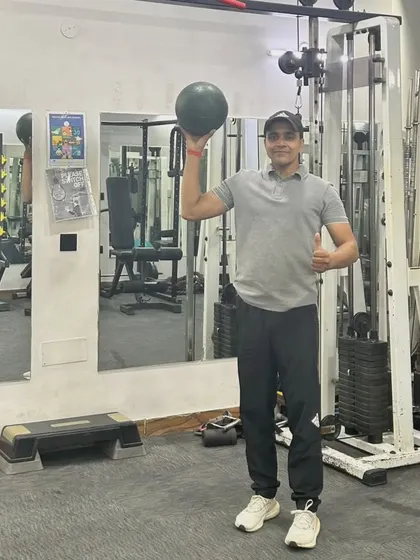 Holding the medicine ball overhead, an exercise that engages the core and shoulders.
