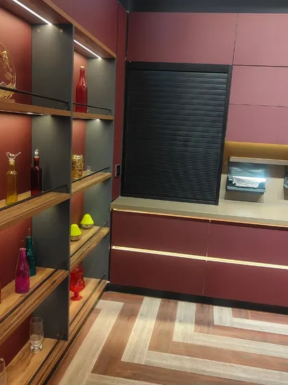 This angle highlights the tall open shelving unit in our magenta kitchen design. It serves as both a functional storage space and a decorative feature, perfect for displaying cookbooks, glassware, or art pieces.