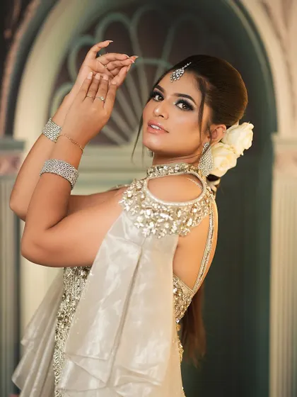 This pose highlights the elegant updo with a fresh flower, a popular choice for modern brides and a style we teach.