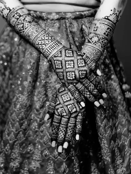 A stunning black and white shot of the bride's intricate Mehendi design, showcasing the artistry and tradition of this beautiful pre-wedding ritual.
