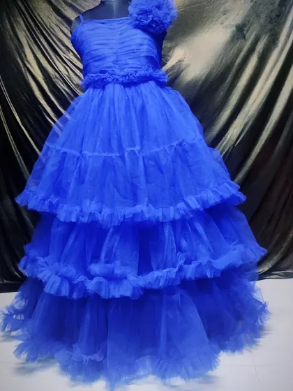 This tiered royal blue ball gown is designed for making an impact. The layers of tulle add volume and texture, creating a classic princess silhouette.