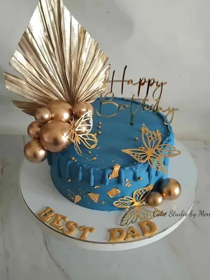 A cake for the best dad. This design in blue and gold features a drip effect, golden butterflies, and a striking palm spear for a modern and masculine look.