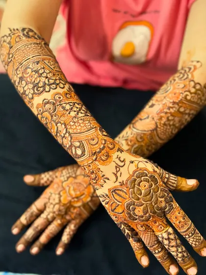 A crossed-hands pose showing the full floral design with the name "Aamir" on the palm.