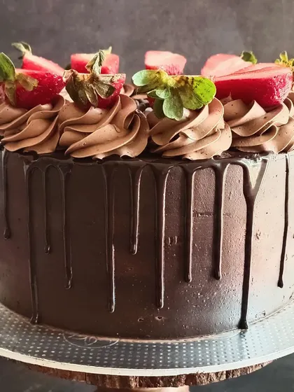 This angle of the Death by Chocolate cake showcases the beautiful, dark chocolate drip effect against the smooth frosting.