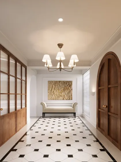 The vestibule was designed as a graceful transition into the home. The classic black-and-white marble flooring, arched wooden door, and ribbed glass partition create a functional and elegant entrance with a distinct European character.