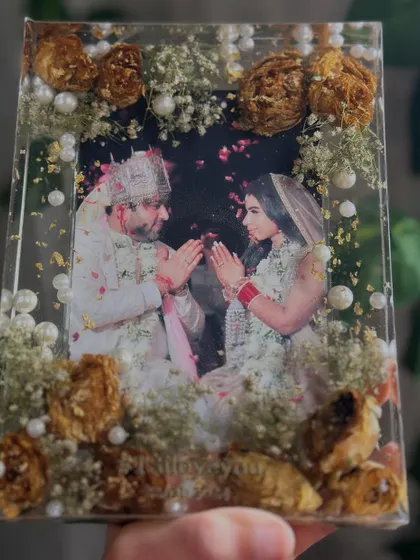 Simplicity at its best. This photo frame uses baby's breath and delicate white flowers to create a soft, dreamy border around the couple's photo. It shows that even simple flowers can create a stunning keepsake.
