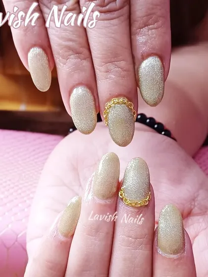 Shimmering gold nails with a unique 3D gold chain detail wrapped around the accent nail, offering a modern and edgy take on bridal embellishments.