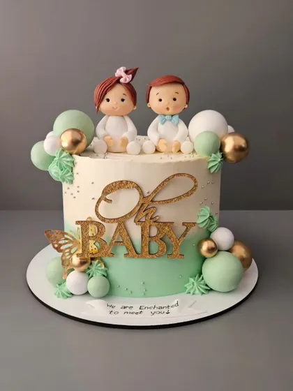 A baby shower cake in a unique and beautiful jade green color. This pistachio cake with strawberry filling is decorated with "Oh Baby" toppers and cute figurines.
