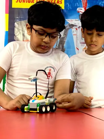 Two students collaborate on programming a wheeled robot. Our small batch sizes ensure teamwork and peer-to-peer learning are a core part of the experience.