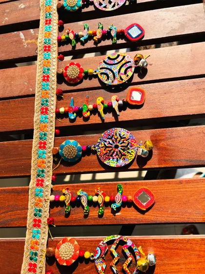 Detail of the 'Rang-Tarang' toran, showing the unique wooden shapes with my art prints and the tiny metal bells that add a delicate jingle.