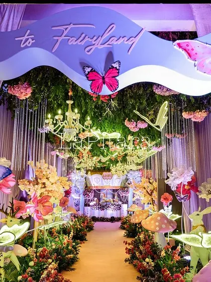 The main entrance arch reading 'Welcome to Fairyland', with a stunning walkway decorated with glowing props and hanging butterflies.