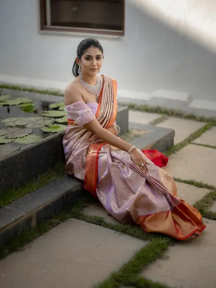 The bride seated by a lily pond, her expression serene. This is a duplicate of ID 18, showcasing a beautiful blend of modern bridal style and traditional elegance.
