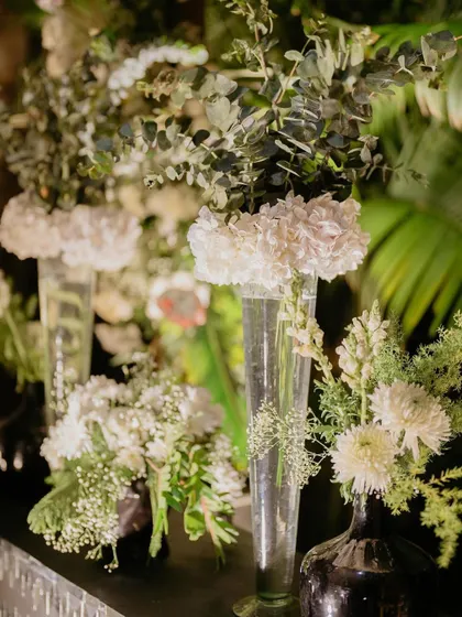 We love playing with different heights and vases to create visual interest. Here, tall glass vases with simple white arrangements add elegance to the bar back.