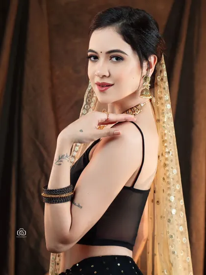 A close-up portrait from the Indo-western series, highlighting the model's soft expression and the delicate gold-dotted dupatta. The warm lighting creates an inviting and gentle mood.