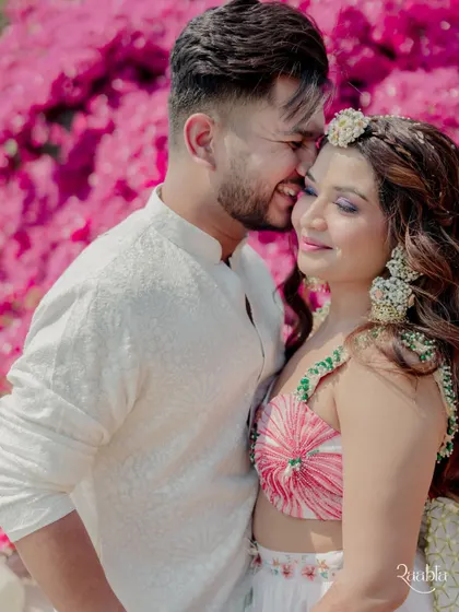A sweet and tender moment between the couple against a backdrop of bright pink bougainvillea.