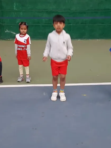 A moment of synchronized jumping during a warm-up. These activities are not just for fitness; they also teach kids to follow instructions and work together as a group.
