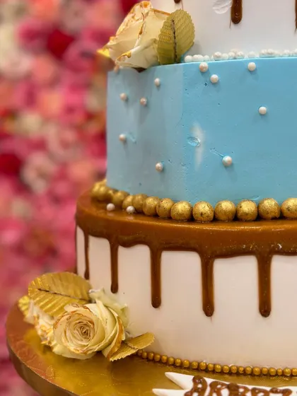 Another detail shot of the three-tiered engagement cake, focusing on the caramel drip and the delicate sugar pearls.